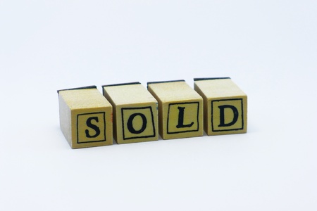 Wooden stamps with letters spelling SOLD isolated on white backgroundの写真素材
