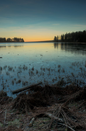 Sunset on the frozen Servieres lake in Auvergne, Puy-de-Dome.の写真素材