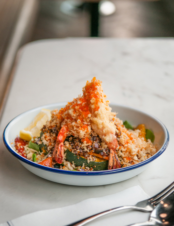 Shrimps tempura with quinoa salad, pumpkin, bell peppers.の写真素材