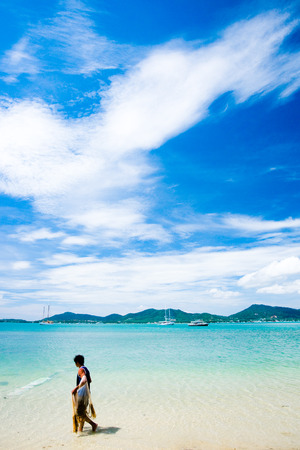 Fisherman walking on the beach in tropical islandの写真素材