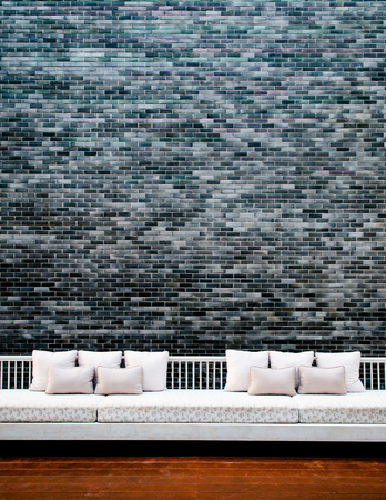 Room with grey brick wall, white coach and wood floor.の写真素材