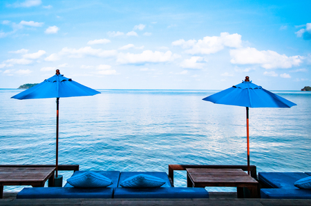 Beach umbrellas, beach bed and blue sea in Thailandの写真素材