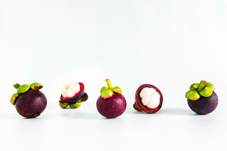 Isolated whole cut open mangosteens on white background.の写真素材