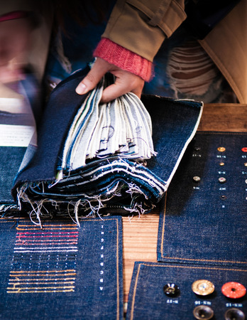 Woman hands chosing  jean fabric, jeans rivets, buttons.の写真素材
