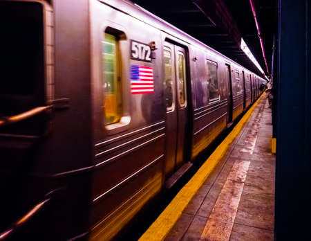 New York City Subway train with USA flag on body.の写真素材