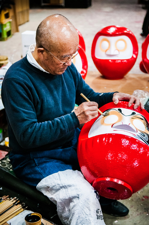 OCT 22, 2014 Takasaki, Gunma, Japan : A man making Daruma  - Traditional Japanese paper mache doll in Daruma workshopのeditorial素材