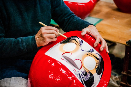 OCT 22, 2014 Takasaki, Gunma, Japan : A man making Daruma  - Traditional Japanese paper mache doll in Daruma workshopのeditorial素材