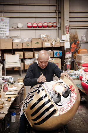 OCT 22, 2014 Takasaki, Gunma, Japan : A man making Daruma  - Traditional Japanese paper mache doll in Daruma workshopのeditorial素材