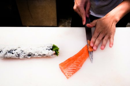 Chef cutting fresh salmon sashimi, top angle shot.の写真素材