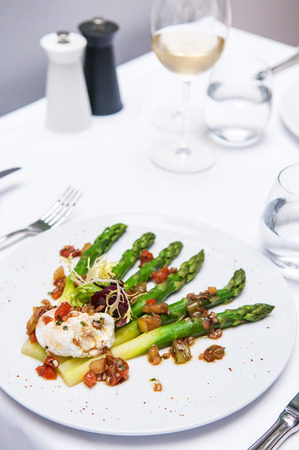 Grilled green asparagus and poached egg with balsamic dressing and tomatoの写真素材