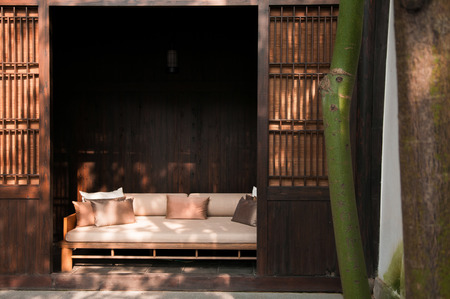 AUG 18, Hangzhou, China : Contemporary Chinese style sofa couch behind wooden doors of old chinese style houseのeditorial素材