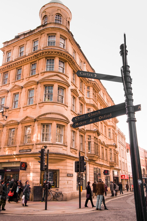 MAR 2, 2011 OXFORD, UK : Steet sign and old brick building at Oxford city center with tourist.