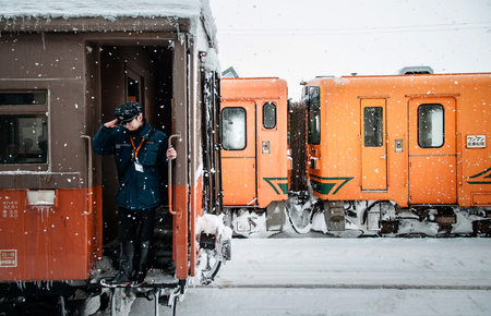 JAN 21, 2014 Aomori, Japan : Train conductor officer riding on vintage potbelly stove train...