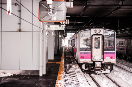 JAN 21, 2014 Hirosaki, Aomori, Japan : Pink strip JR East 701 Series commutor train at Hirosaki Station in winter, EMU train opperated on Ou Main Line between Akita and Aomoriのeditorial素材