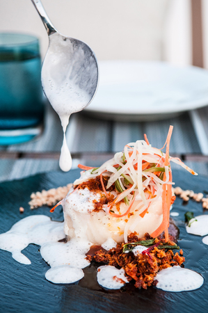 Grilled cod fish with  lemon foam sauce, Thai herbs crumb and shredded carrot and daikonの写真素材