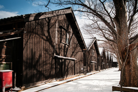 Vintage old Japanese black warehouse in winter snow and tree line, Sakata Sunkyo Soko, Yamagata   orefecture, Japanの写真素材