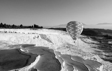 Hot air balloon flying over Travertine pools limestone terraces on beautifulday in Pamukkale, Denizili, Turkeyの写真素材