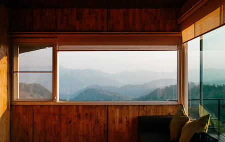 Morning forest and mountain view from wooden cabin living room window in Chiang Mai, Thailandの写真素材