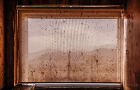 Very Old dirty grunge curtain in wooden cabin with black mold fungus and mountain view