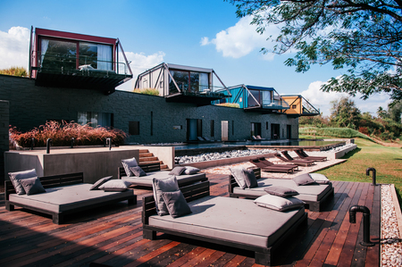 FEB 23, 2015 Kanchanaburi, Thailand : Beautiful modern loft vacation villa with balcony and pool by the river at X2 Resort in evening light - contemporary loft architecture designのeditorial素材