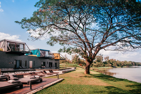 FEB 23, 2015 Kanchanaburi, Thailand : Beautiful modern loft vacation villa with balcony and pool by the river at X2 Resort in evening light - contemporary loft architecture designのeditorial素材