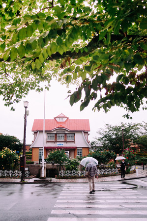 JUNE 24, 2014 - Ota - Tokyo, Japan : Old vintage building architecture of Den en chofu Station during raining in early spring season with local people walking under umbrellaのeditorial素材