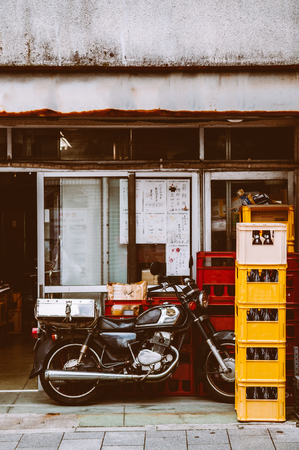 June 25, 2014 Shinagawa, Tokyo, Japan : Old vintage  motorcycle behind local restaurant with colourful beer boxesのeditorial素材