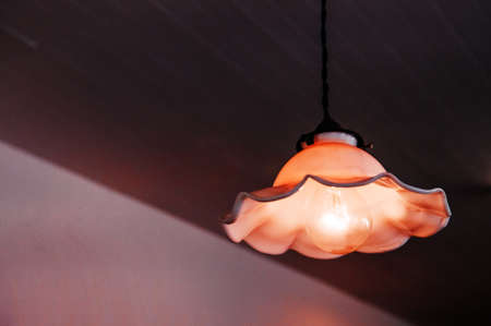 Rustic vintage ornamental vintage ceramic glass hanging lamp on dark background in living roomの写真素材