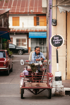 MAR 3, 2018 Uthaithani - Thailand : Thai local old man on a traditional  vintage sidecar with vintage street signのeditorial素材