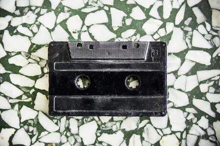 Retro plastic audio cassette, music cassette, cassette tape. Isolated on terrazzo texture background. Vintage cassette tape.の写真素材