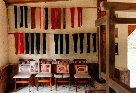 JAN 31, 2013 Iriomote, Okinawa, Japan : Japanese vintage old living room with wooden chairs and shibori dye fabric hanging on old wallのeditorial素材