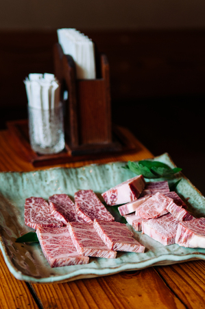Close up fresh raw Ishigaki beef wagyu A5 premium grade on craft ceramic plate at local restaurant, Okinawa, Japanの写真素材