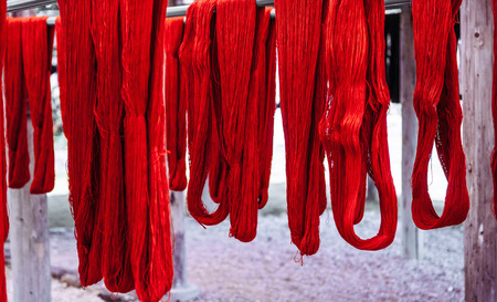Handmade Okinawa traditional silk or cotton fabric textiles, red colour natural dye thread, close up...