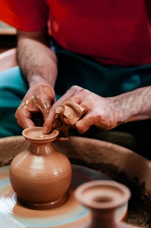 Man making Okinawa style pottery art, clay work close up hands shotの写真素材