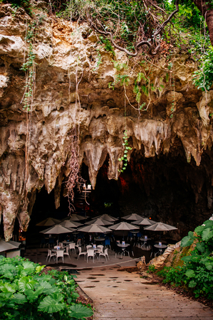 JAN 28, 2013 Naha, Okinawa, JAPAN : Oxotic Okinawa World Bunka Okoku Gyokusendo, Cave cafe tables and umbrellas in Gangala valleyのeditorial素材