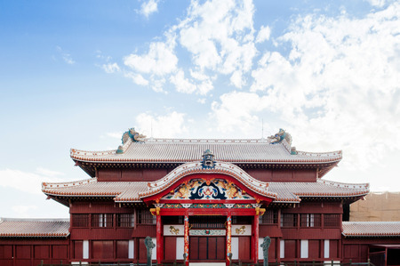 Red Main hall of Shuri (Shurijo) Castle under clear blue sky with tourists, Naha, Okinawa, Japan