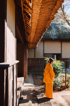 DEC 11, 2012 Chiba, JAPAN - Old vintage wooden thatched roof Japanese Samurai house and woman in Yukata dress. Sakura city, famous Edo Samurai village near Tokyo.