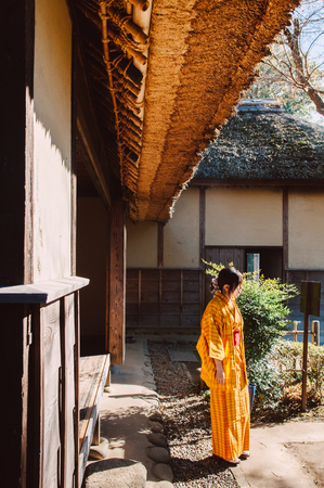 DEC 11, 2012 Chiba, JAPAN - Old vintage wooden thatched roof Japanese Samurai house and woman in Yukata dress. Sakura city, famous Edo Samurai village near Tokyo.