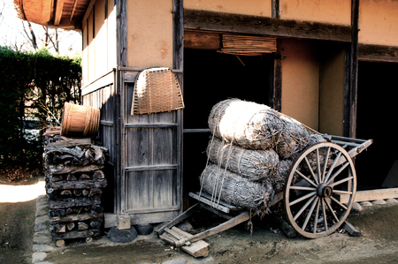 DEC 12, 2012 Chiba, JAPAN - Wooden cart, firewood and thatched roof house at Boso No Mura Open air museum, Edo town ancient villageのeditorial素材