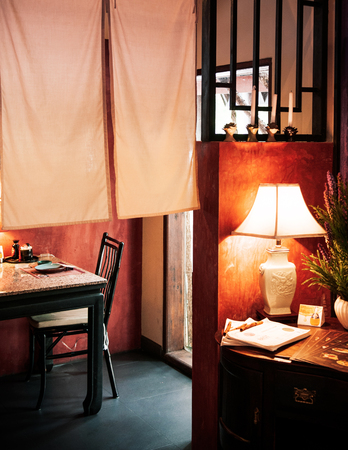JUN 5, 2013 Chiang Mai, THAILAND - Nice vintage Chinese interior style dinning room with lamp, table, wooden chair and curtain. warm lightの写真素材