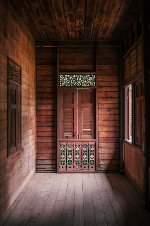 Old grunge wooden corridor and window in old abandoned house in Phrae, Thailandの写真素材
