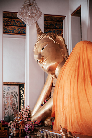 Old golden face of reclining Buddha statue of Wat Ratchaorotsaram  Bangkok, Royal temple in Thonburi district.のeditorial素材