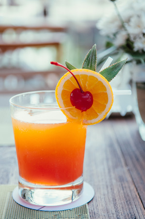 A glass of fresh squeeze orange juice with orange slice and pickled cherryの写真素材