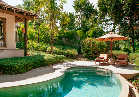 FEB 6, 2013 Phuket, Thailand - Vacation tropical resort villa free form infinity pool, beach bed...