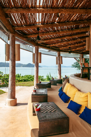 FEB 6, 2013 Phuket, Thailand - Sea view bar in island resort warm atmosphere, wooden interior, colourful fabric cusion and pillows with old wood coffee tableのeditorial素材