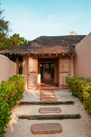 FEB 6, 2013 Phuket, Thailand - Vacation tropical resort in garden with clay house design, warm wall color, wooden pavilion with thatched roofのeditorial素材