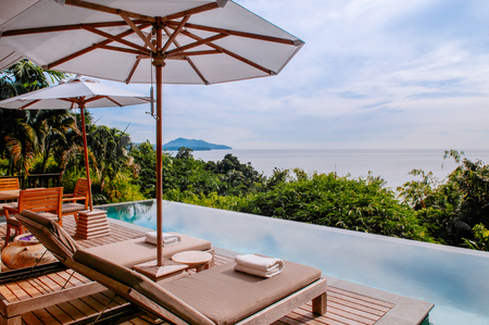 FEB 9, 2013 Phuket, THAILAND - Vacation Relaxation resort daybed under umbrella by the infinity pool with ocean viewのeditorial素材