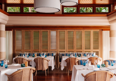 FEB 9, 2013 Phuket, THAILAND - Vintage dinner table and rattan chairs in coloniel designed restaurant, indoor dinning area with wooden interior decoration.のeditorial素材