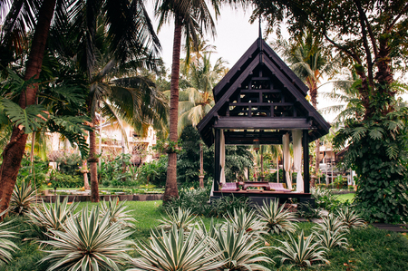 NOV 13, 2013 Samui, Thailand - Thai pavilion in lush tropical garden with coconut tree green agave, luxury resort landscapeのeditorial素材