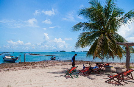 NOV 11, 2013 Samui, Thailand - Local Thai tourists sitting on colourful beach beds under coconut tree on Koh Tean near Koh Samui. Thailand summer vacation on small islandのeditorial素材